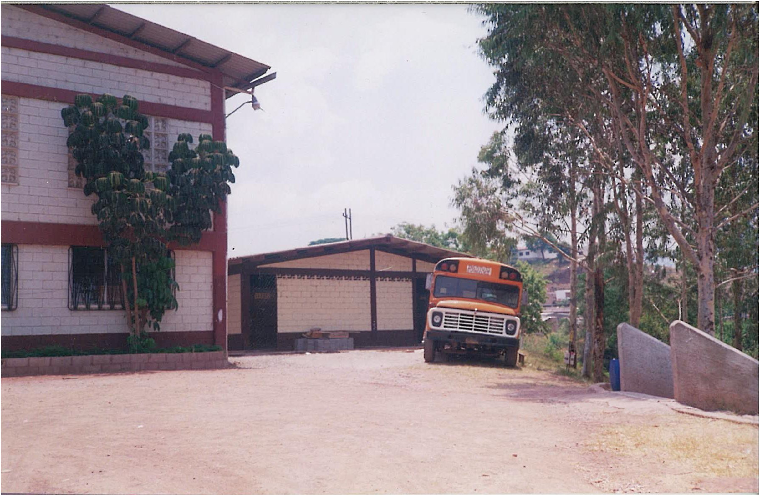 Bus escolar del instituto estacionado junto a los primeros pabellones de aulas
